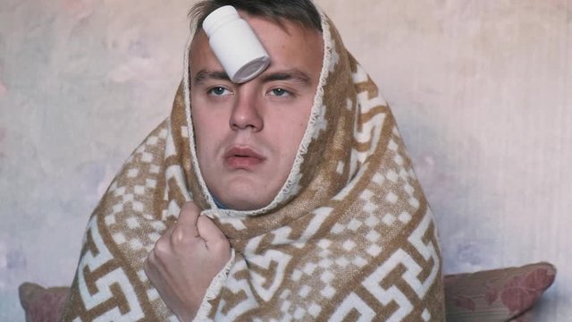 Funny young man with flu or cold symptoms in a plaid coughs, close   up