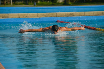 Obraz na płótnie Canvas Swimmer standing next to a pool on a sunny morning