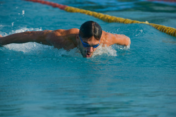 Swimmer standing next to a pool on a sunny morning