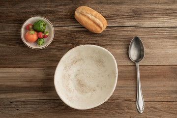 an empty soup bowl and bread on a wooden table