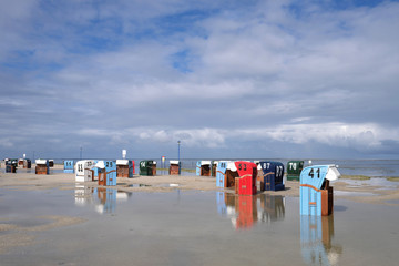 Wattenmeer und Strand von Neuharlingersiel an der Nordsee nach heftigem Regen mit Strandkörben und Pfützen und Wasserlachen - Stockfoto