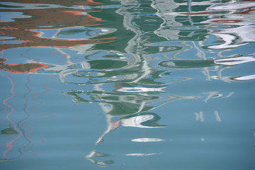View of the harbor water surface reflecting nearby boats