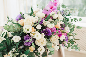Floral wedding decoration. Wedding table setting decorated with fresh flowers. Wedding floristry. Bouquet with roses, eustoma and eucalyptus leaves.