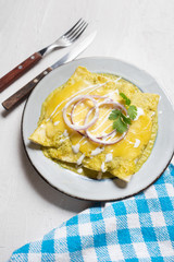 Mexican green enchiladas with melted cheese also called 
