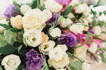 Floral wedding decoration. Wedding table setting decorated with fresh flowers. Wedding floristry. Bouquet with roses, eustoma and eucalyptus leaves.