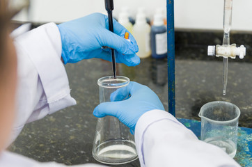Woman hands performing titration test on chemical quality contro
