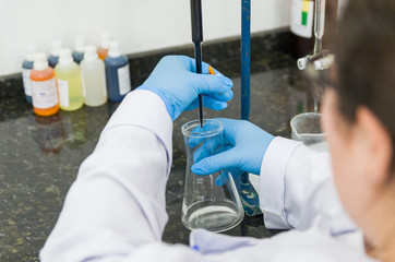 Woman hands performing titration test on chemical quality contro