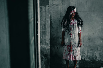 Girl zombie in the blood.The ghost of a woman stand with resentment torture and ask for help, in abandoned building, Halloween murder concept.