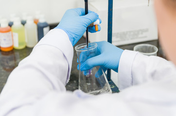 Woman hands performing titration test on chemical quality contro