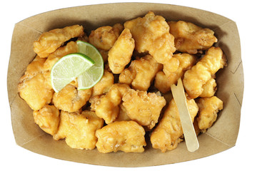Kibbeling in a cardboard tray isolated on white background. Kibbeling is a Dutch snack consisting of battered chunks of fish. It is a very popular dish in the Netherlands.