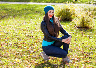 Happy woman in black leather jacket and blue knitted hat