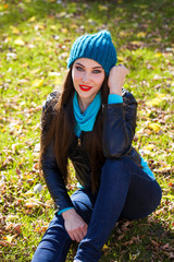 Happy woman in black leather jacket and blue knitted hat