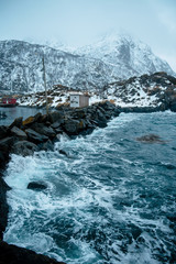 Fototapeta premium Norway. Stone breakwater that separates the ocean from fishing town.