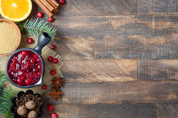 Fototapeta na wymiar Cranberry sauce with ingredients on a wooden background. Top view, flat lay, copy space.