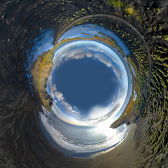 Inverted little planet of landscape of the black sand beach in Stokksnes on a sunny day. Vestrahorn...