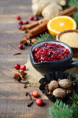 Cranberry sauce with ingredients on a wooden background.