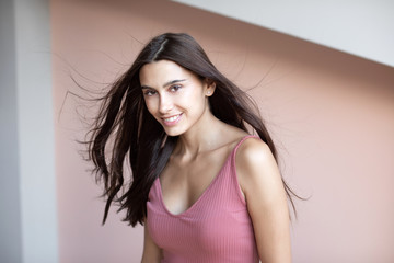 Young beautiful woman with hair in the wind indoors.