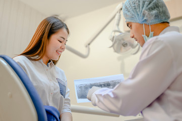 The dentist is looking at the patient's dental x-ray results for an effective treatment and improves the patient's dental health and a bright smile..