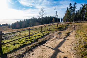Hiking trail in mountains with wooden fence along the path