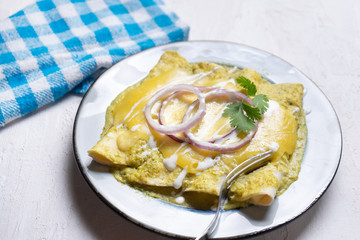 Mexican green enchiladas with melted cheese also called 
