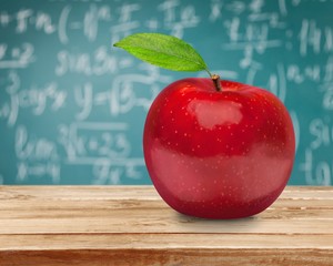 Photo of red apple with A+ on the school desk
