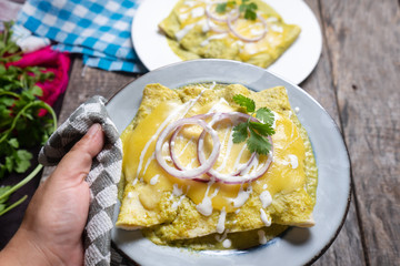 Mexican green enchiladas with melted cheese also called 