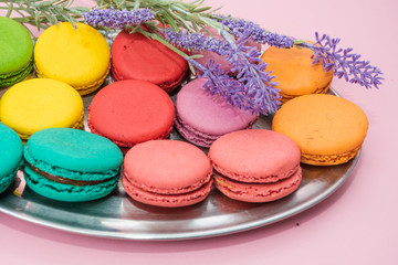 Multicolored macaroons on pink background. Sweet and colourful french macaroons