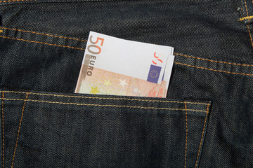 Euro banknotes in dark blue jeans back pocket.