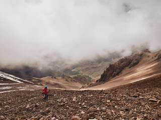 Naklejka premium Tourist on hike descending to dramatic mountain valley of Tacheddirt