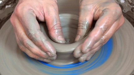 Detail of hands modeling clay, handmade rat, traditional wheel