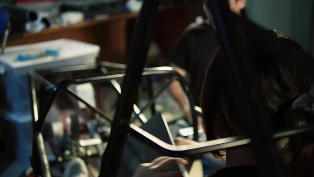 Asian engineer students are updating software with assembling and testing electric vehicles at the university. Concept of configuration, technological developments and renewable energy.