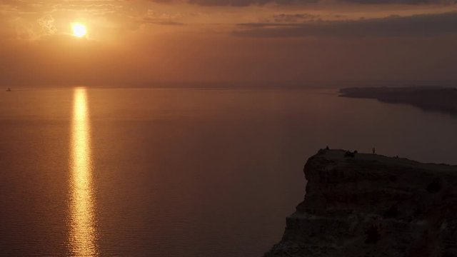 Aerial view of a golden sunset sky background with evening clouds over the sea. Shot. Stunning sky clouds in the sunset with a bright sun path on the sea surface.