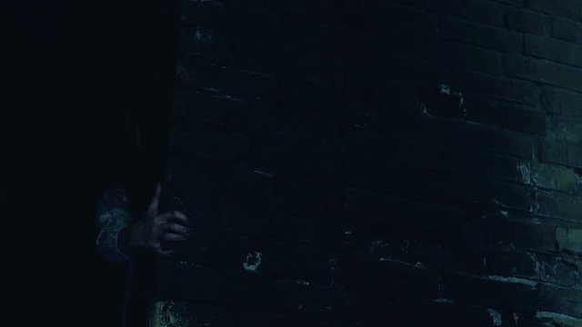 Fearful zombie looking out scary haunted house, blood-thirsty monster attack