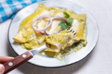 Mexican green enchiladas with melted cheese also called 