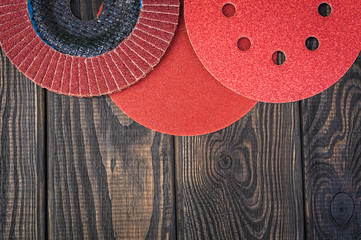 Set of abrasive tools and sandpaper different colors on black vintage wooden background