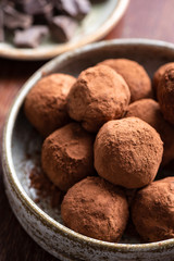 Dark chocolate truffles in a bowl, closeup view. Tasty chocolate candy