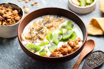 Breakfast yogurt bowl with fruits kiwi, banana, chia seeds and granola. Clean eating, diet vegetarian food. Healthy eating concept