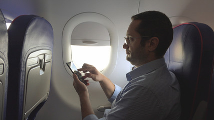 Business man on plane set looking on smart phone, connection overall