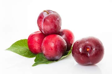 plums with plum leaves on a white background