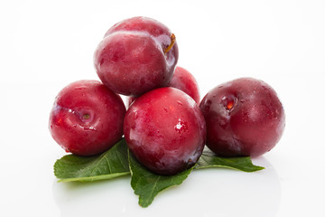 plums with plum leaves isolated on a white background