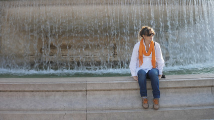 Young beautiful woman relax near fountain in Rome city center