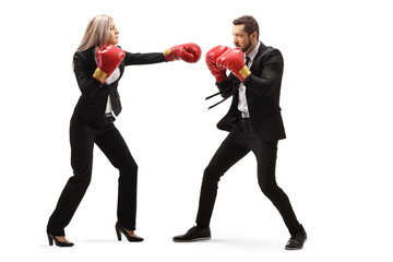 Businessman and businesswoman in sparring with boxing gloves