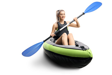 Young female in a canoe with paddles smiling