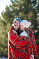 Winter walk through the woods. The guy in the red plaid blanket wraps the girl up so she gets warm