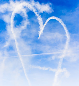 Heart shape with cupids arrow written in the sky with smoke