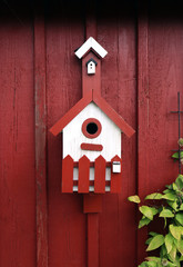Home sweet home. House for a little bird on the red wall during late Summer.