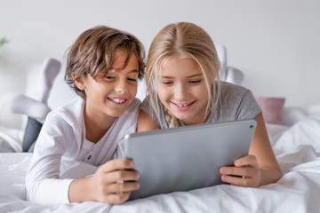 Cute little children with digital tablet using internet at home