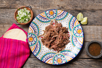 Mexican slow cooked lamb also called barbacoa on wooden background © Guajillo studio