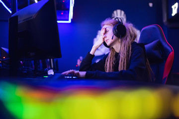 Fototapeta na wymiar Streamer beautiful girl regrets losing professional gamer loser playing online games computer, neon color