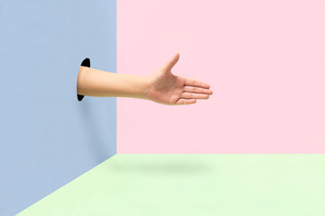 Hand offering a greeting on colorful background. © Guajillo studio